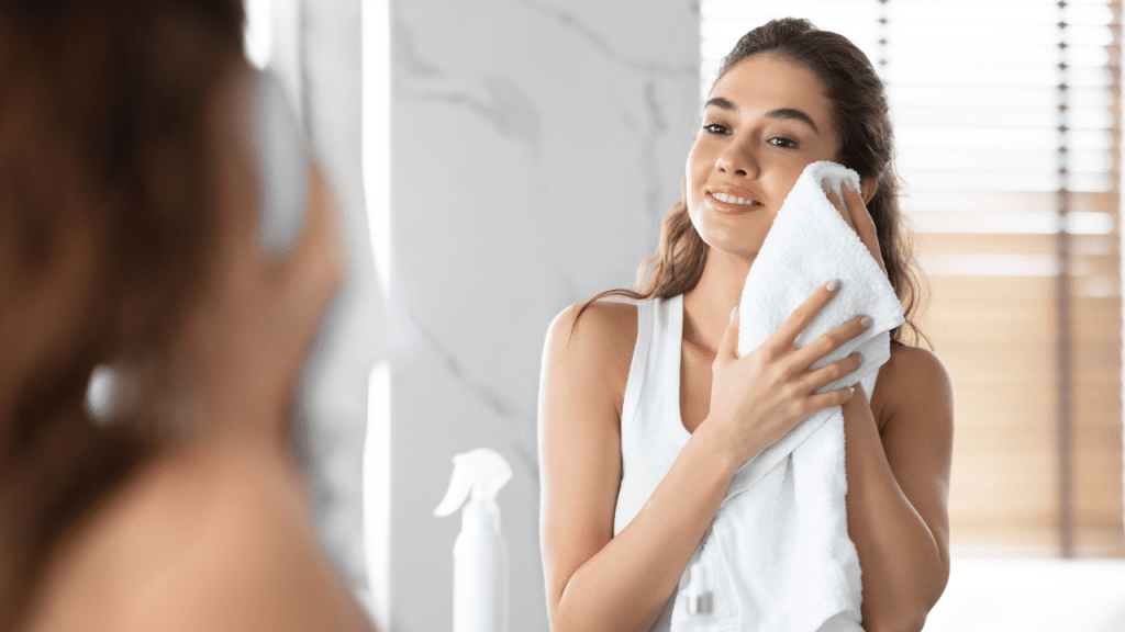 Teen applying skincare in the mirror